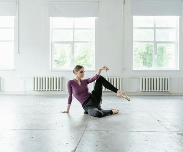 Person performing a gentle stretching exercise in a bright, clean room.